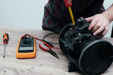 Elektrikli süpürge tamiri. Profesyonel teknisyen ofisinde modern elektrik süpürgesini tamir ediyor..