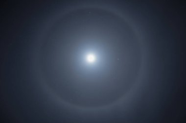 Ay 'ın etrafında güzel bir kış halesi. Yıldızlarla çevrili dairesel gökkuşağı halkası olan süper ay.