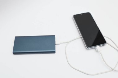güç bankası ve beyaz arkaplanda akıllı telefon.