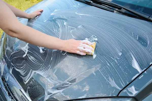 Woman washing a car. Cropped Image Of Hand Washing Car. woman washing car on driveway