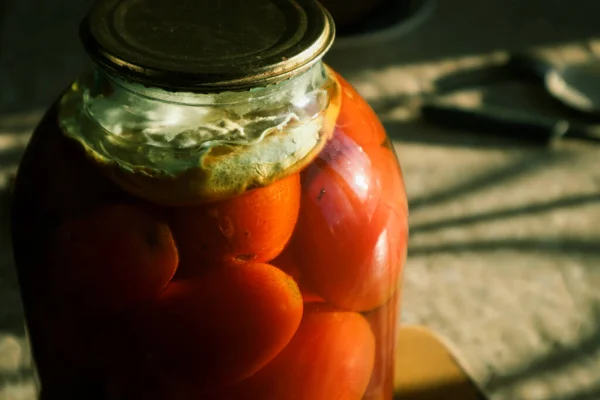 Canned tomatoes in glass jar, marinated tomato. Close up view of homemade delicious pickled tomatoes.