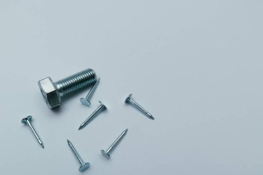 Set of bolts, screws, nails. Construction abstraction. Industrial background. Screws and bolts macro photo, white background, steel screw, bolt macro.