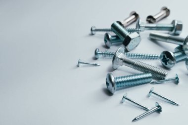 Set of bolts, screws, nails. Construction abstraction. Industrial background. Screws and bolts macro photo, white background, steel screw, bolt macro.