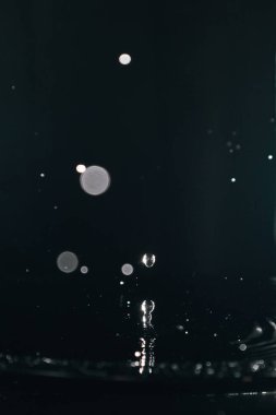 Su sıçrat. Su damlası siyah arkaplana yakın sıçrıyor.