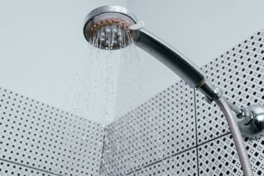 Silver shower head with limescales. Shower damaged from water scale. Hard water deposit all around the sprinklers clipart