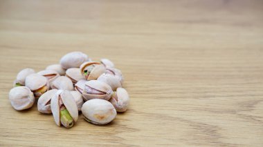 Tahta bir masada fıstıklı fıstık. Fıstık arkaplanı, metin için yer.