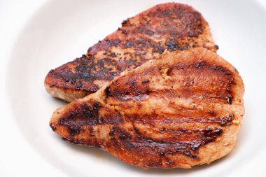 Beyaz tabakta ızgara kırmızı ton balığı bifteği ve biber makrosu. Beyaz Tabakta İki Kızarmış Ton Bifteğinin Yakın Durgun Yaşamı