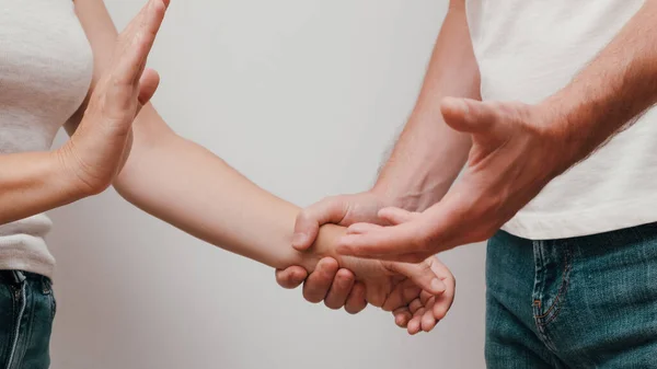 コミュニケーションの問題を持つ若いカップル 暴力行為で女性の手を握っている男 白で隔離された積極的な関係の概念 — ストック写真