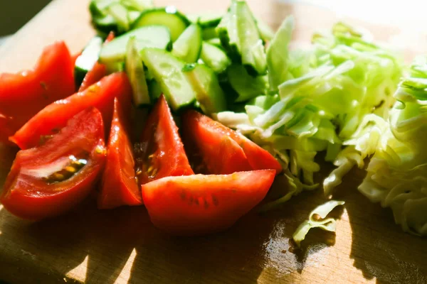 野菜サラダを調理する 野菜チョッピングプロセス 女性はキッチンでサラダのためにキュウリとトマトをチョッピングします ナチュラルサンライティング — ストック写真