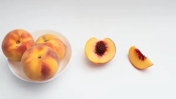 Frische Reife Pfirsiche Auf Einem Weißen Teller Ein Halber Und — Stockfoto