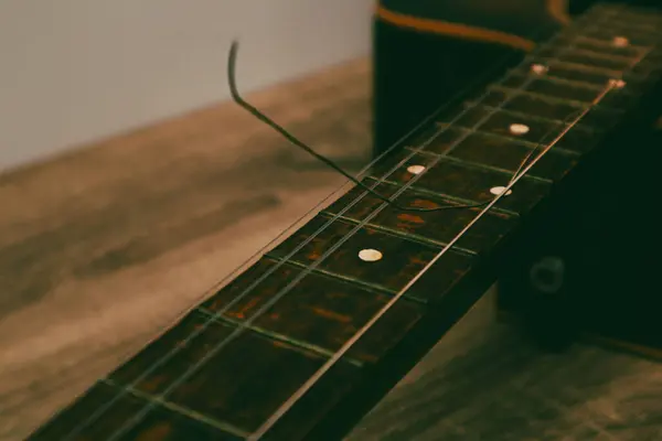Closeup of classical acoustic wooden guitar with a broken string. Classical guitar with broken string.