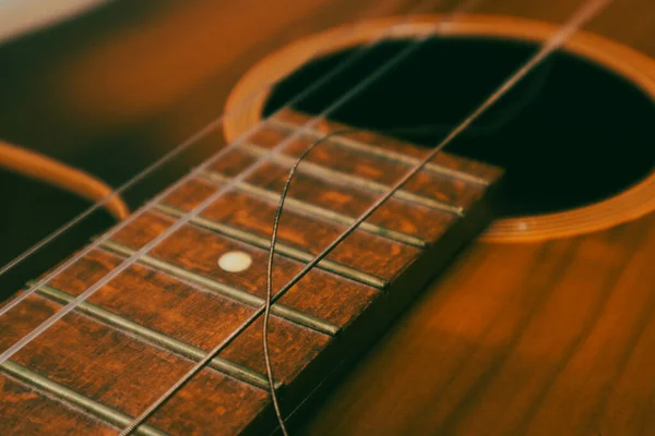 Closeup of classical acoustic wooden guitar with a broken string. Classical guitar with broken string.