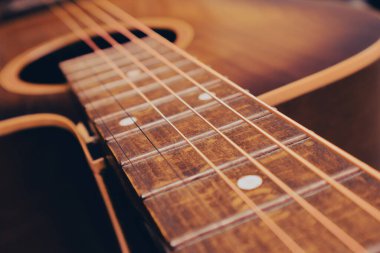 Yeni telli akustik gitar teli ve klavyeyi kapat. Çelik telli eski bir tahta gitarın fotoğrafı. Dizgiler kapansın.