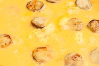 Sosisli omlet yapıyorum. Çırpılmış yumurta için sıvı yumurta kızartma tavasına dökülüyor..