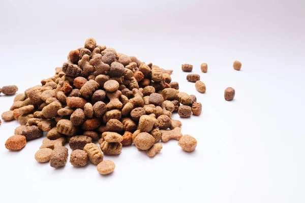 A slide of dry dog food on a white background. Heap of dry dog food on a white background. Pets food