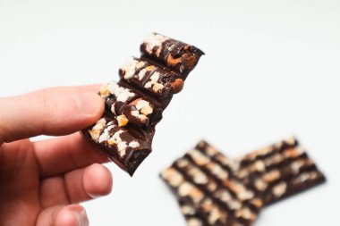 Çikolata yiyen bir adam. Elinde fındık olan bir parça acı, siyah çikolata. Şeker bağımlılığı.