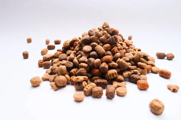 A slide of dry dog food on a white background. Heap of dry dog food on a white background. Pets food