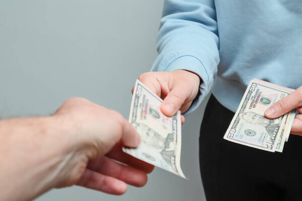 Женщина дает бумажные американские долларовые купюры. Наличные. Заплати кому-нибудь долларами. Подкуп и коррупция. Мы деньги в руках.