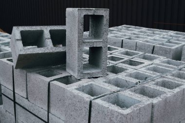 Hollow concrete wall blocks assembled on pallets. Finished products stacked on pallets on construction site. clipart