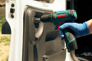 Araba tamiri. Kırık araba süsleme paneli bağlayıcılarını değiştiriyoruz. Tornavida kullanarak paneli kaldırılıyor