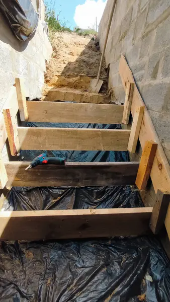 stock image Construction of a bomb shelter. Making wooden formwork for pouring concrete steps into the shelter.