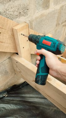 İnşaat alanında elektrikli matkap. Efendinin elindeki tornavida yakın plan. Bina konsepti. Beton merdivenler. Merdiven yapısı..