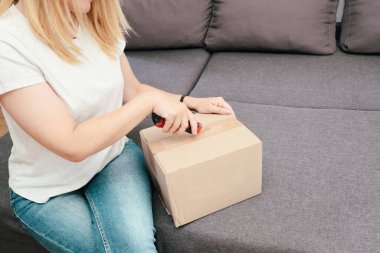 Kadın Kutuyu Açar. Karton kutu teslimatı yapan bir kadın. Karton kutuları bıçakla açan kadın.