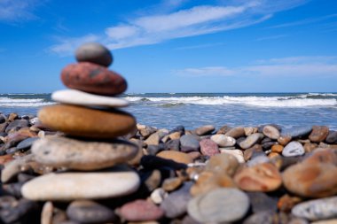 Bir çakıl taşı plajında dengeli taşlar. Kıyıdaki taşlar dengede. Deniz sahilinde Zen Taşları, meditasyon, spa, uyum, sakinlik, denge konsepti.