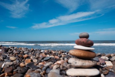 Bir çakıl taşı plajında dengeli taşlar. Kıyıdaki taşlar dengede. Deniz sahilinde Zen Taşları, meditasyon, spa, uyum, sakinlik, denge konsepti.
