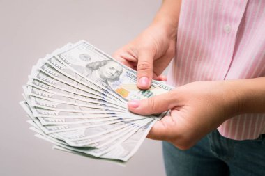 Kadın eli bize dolar tutuyor. Fotokopi alanı ile kredi ve borç kavramı. Elinde dolarlar olan bir kadın.