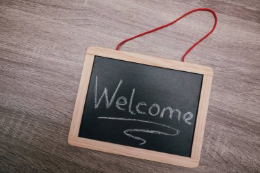 Tahtaya elle yazılmış hoş geldin tabelası. Hoş geldiniz yazılı tahtası