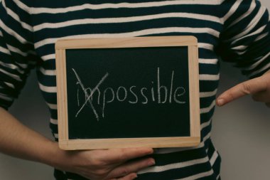 İmkansızı mümkün kılıyor. Kadınların elindeki tahtanın üzerine beyaz tebeşirle yazılmış olanaksız. Başarı motivasyonu, şüphelerden kurtulmak