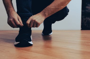 Ayakkabı bağcığı bağlayan koşu ayakkabısı adam. Sporcu antrenmana hazırlanıyor. Koşu ayakkabısı giyen bir adam. Ayakkabı giyen adam antrenmana hazırlanıyor.