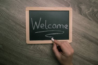 Tahtaya elle yazılmış hoş geldin tabelası. Hoş geldiniz yazılı tahtası