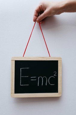 İzafiyet teorisi kütle enerjisi denklemini oluşturur. Tahtaya ya da tahtaya elle yazılmış denklem