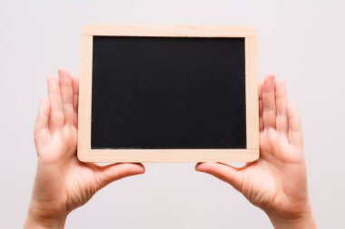 Karatahta gösteren bir kadın eli. Tahtaya yazı yazmak için uygun bir yer. Boş Karton Çerçeveyi Tutan Eller.