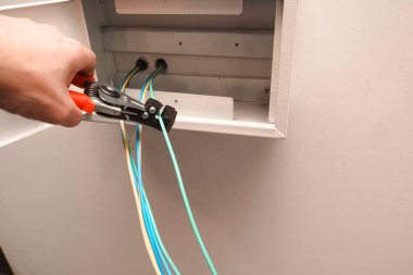 Elektrik paneli kurulumu. Kablolu elektrik santrali. İş aracı ile çalışan elektrikçi