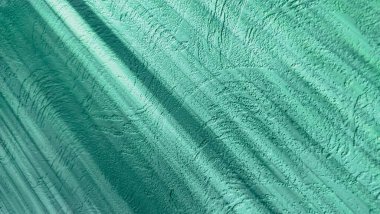 Beyaz duvardaki bir kör gölgesi. Beyaz taştan bir duvarda çapraz çizgili gölgeler. Işık ve gölgeler renk duvarına düşüyor.