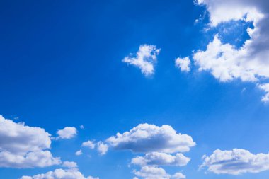 Güneşli bir günde mavi gökyüzü ve bulutlar. Mavi gökyüzü ve beyaz bulutlar. Mavi gökyüzü arka planda bulutlar, bulutlu ve gökyüzünde güneşli güzel bir manzara..