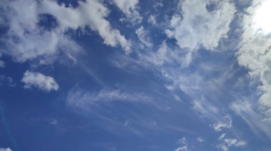 Mavi gökyüzünde farklı şekillerde beyaz bulutlar. Serene mavi arka plan. Parlak güneşli bir günde bulutlu bir manzara. Cirrus Bulutları