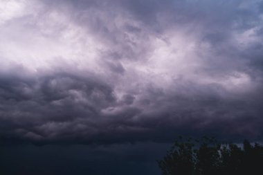 Gün batımında güzel, renkli, fırtınalı bir gökyüzü. Fırtınalı gökyüzü ile gün batımı. Fırtınalı bulutları aşan dramatik bir gün batımı.