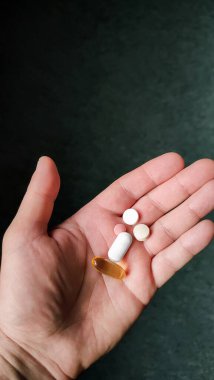 Haplar, ilaçlar ve günlük kapsüller ve haplar alan yaşlı bir adamın sağlık hizmetleri. Sağlık sigortası konsepti. Kapat elini, birden fazla hap alıyor. İlacı eline al.