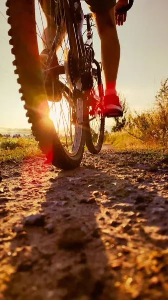 Gün batımında bisikletli siluetli bir adam ve mesaj için yeri var. Maceraya başlayalım. Gün batımında çakıllı bir yolda bisiklet süren bir adam.