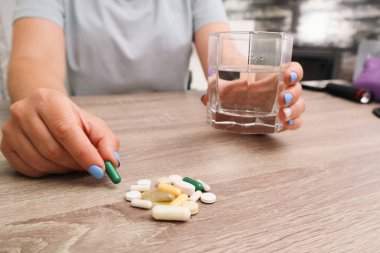 Evde tedavi için vitamin ya da hap alan bir kadın. Kadın vitamin ve takviye alıyor. Tıbbi konsept.