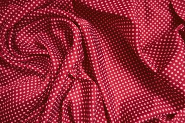 Kırmızı ipek kumaş perdeler, zarif dalgalar, arka plan, tekstil tasarımı. Kırmızı renkli saten kumaşın yakın plan çekimi pürüzsüz ve parlak dokusunu gözler önüne seriyor.