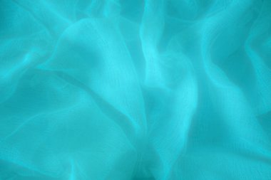 Yumuşak kıvrımlı ve kumaşlı mavi ipek kumaş. Moda projeleri, markalaşma, tasarım veya reklamcılık için soyut bir arkaplan olarak mükemmel.