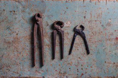 Düz bir yüzeyde üç klasik kıskaç üst görünümde yatıyordu.