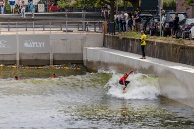 Rotterdam, Hollanda - 30-06-2024: Hollanda 'nın Rotterdam kentindeki Rif010 kentsel sörf havuzunda bir kadın sörfçü