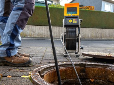 Bir drenaj temizleme şirketi sifonu çekmeden önce tıkalı bir drenajı kamerayla kontrol ediyor.