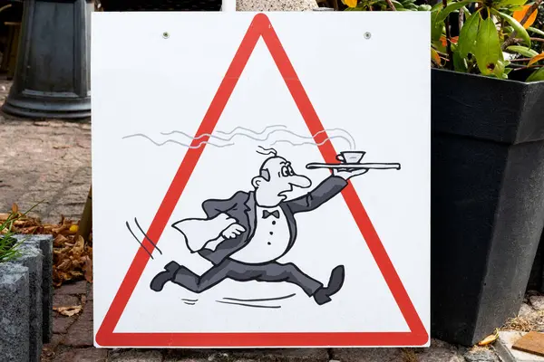 Caution, running waiter with coffee cup on the serving tray. Triangle, funny waiter traffic sign in front of a cafe